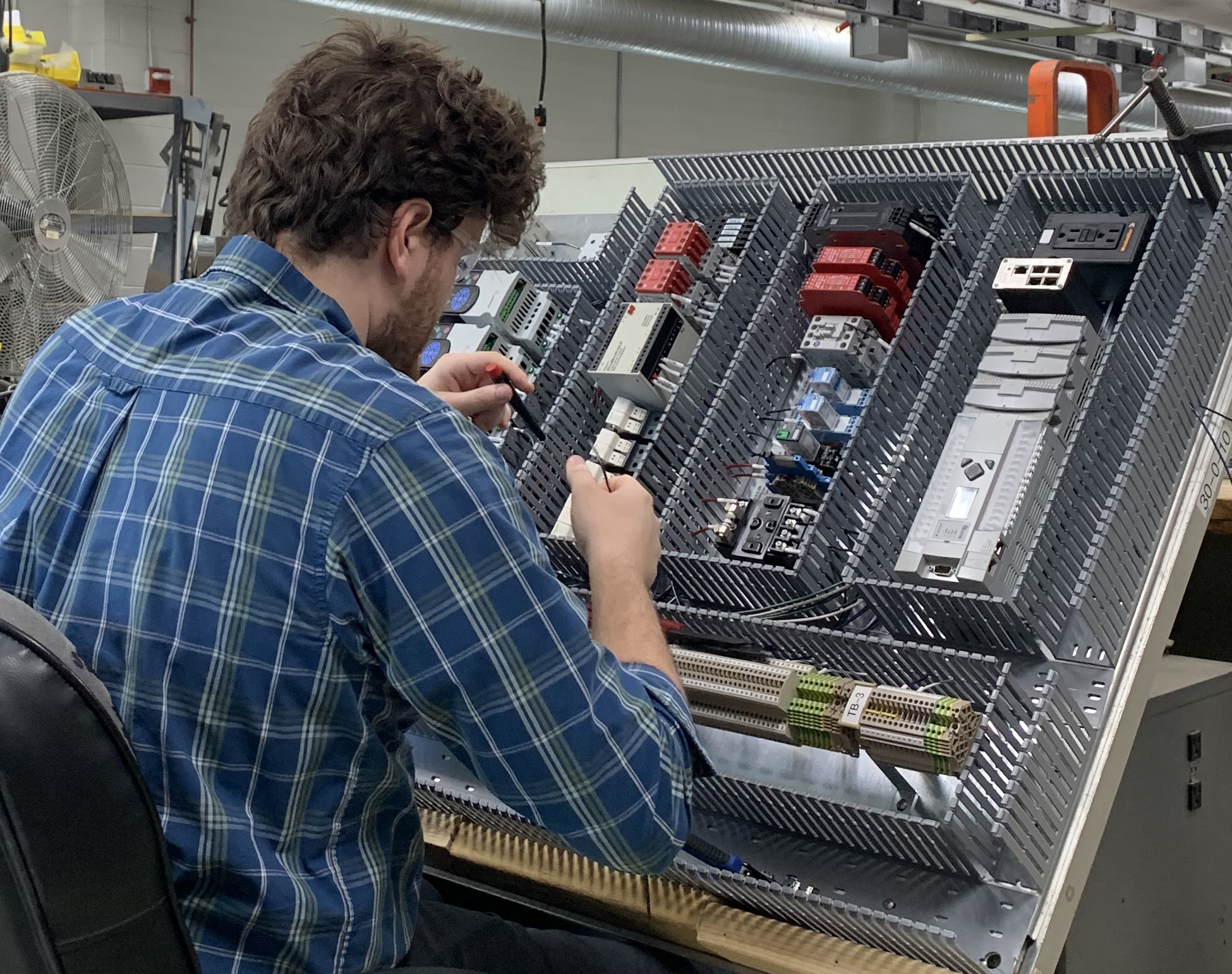 Technician wiring up a panel for shrink sleeve machine